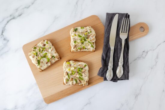 veganer Flammkuchen Toast auf Holzbrett