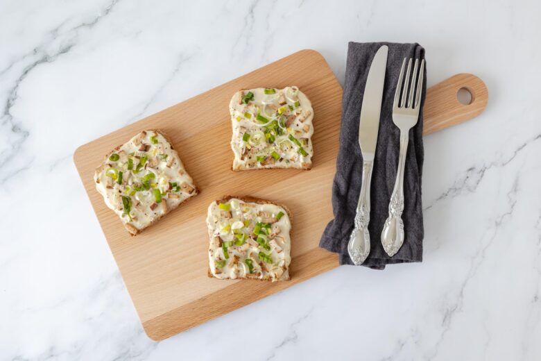 veganer Flammkuchen Toast auf Holzbrett