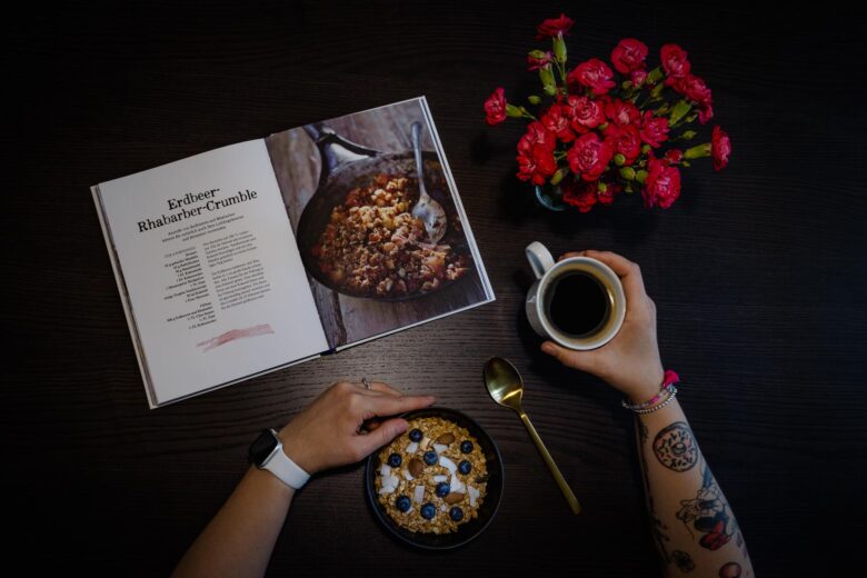 Stefanie am lesen und Kaffee trinken von oben Arm Tattoos