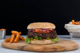 Blackbean Burger mit Fries auf Holz von vorne