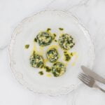 gnudi auf dem teller mit besteck und salbei butter und serviette
