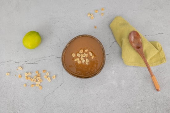 erdnuss sauce mit limette und holzloeffel