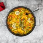 Vegane Paella mit Gemüse mit Löffel uns Serviette