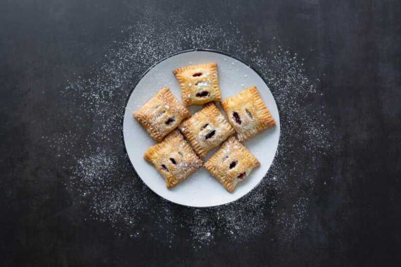 Golden gebackene Zwetschgentaschen mit Puderzucker bestreut