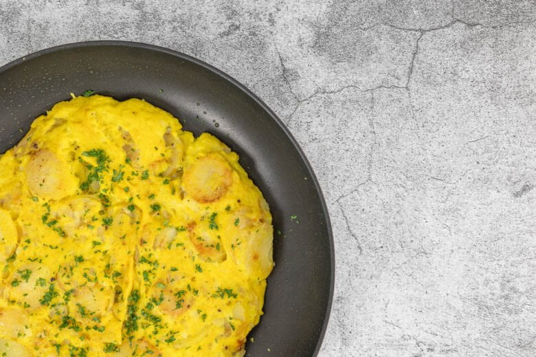 Vegane Tortilla ohne Ei von nahem in der Pfanne mit Scheibenkartoffeln