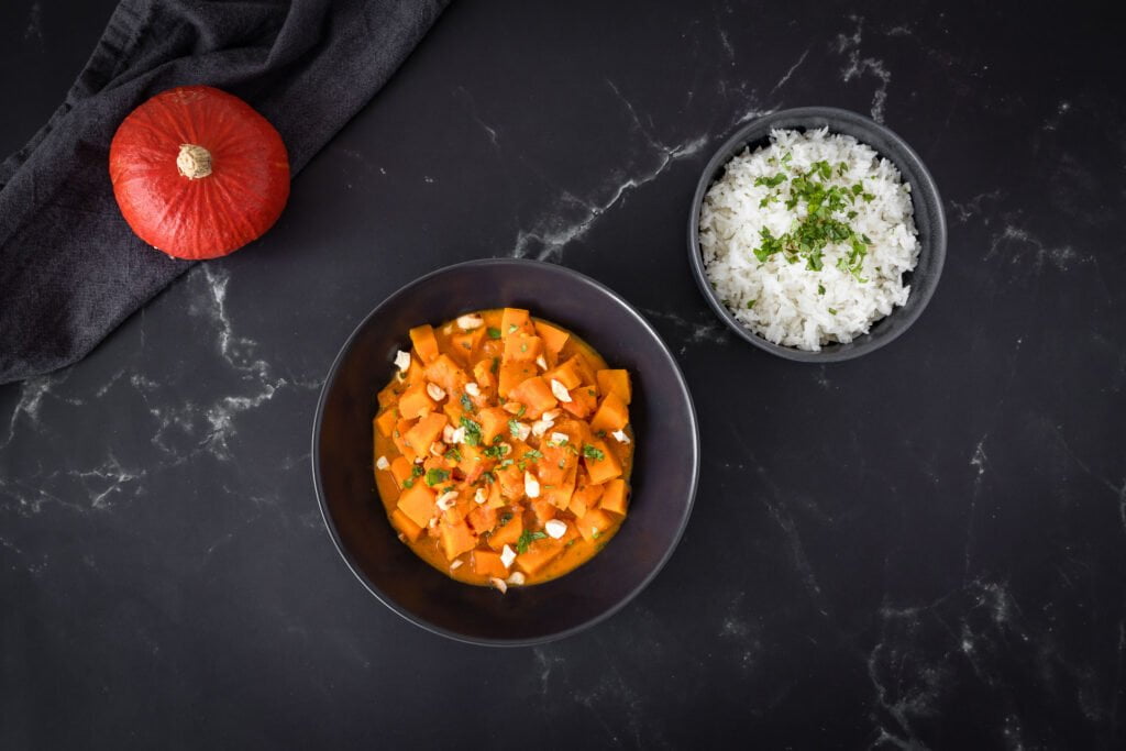 Veganes Kuerbis Curry mit Kuerbis auf dem Tisch