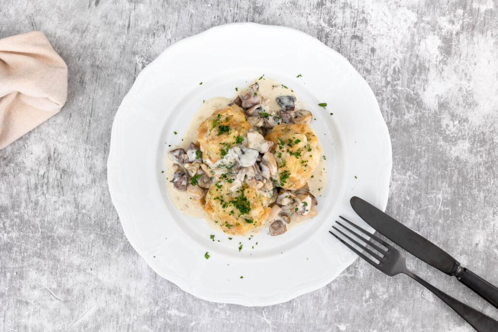 Vegane Semmelknödel mit veganem Pilzragout angerichtet auf dem Teller