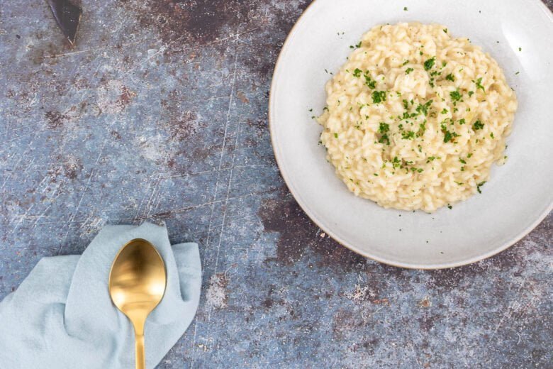 Veganes Risotto mit blauer Serviette und Löffel