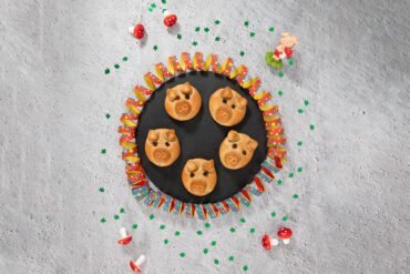 Vegane Glücksschweine aus Hefeteig auf einer Platte mit Silvester Dekoration