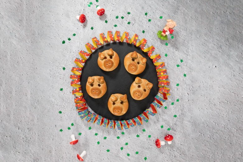 Vegane Glücksschweine aus Hefeteig auf einer Platte mit Silvester Dekoration