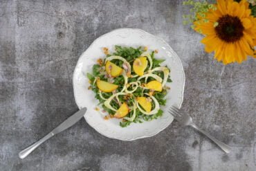 Rucolasalat mit Fenchel, Nektarine und Baumuessen mit Sonneblume Deko