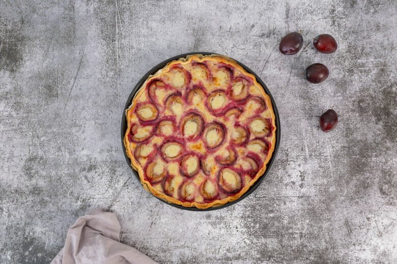 Vegane Zwetschgenwaehe mit Zwetschgen auf dem Tisch