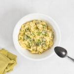 Veganer Kartoffelsalat - Der beste Härdöpfelsalat der Welt in einer Schüssel mit dem Löffel zum Servieren und mit einer Serviette