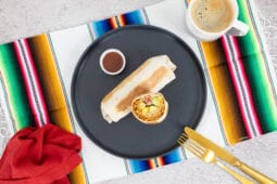 Veganer Breakfast Burrito auf einer mexikanischen bunten Tischdecke mit Kaffe und Serviette
