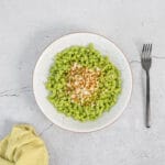 Vegane Bärlauchspätzli auf dem Teller mit Gabel und Serviette