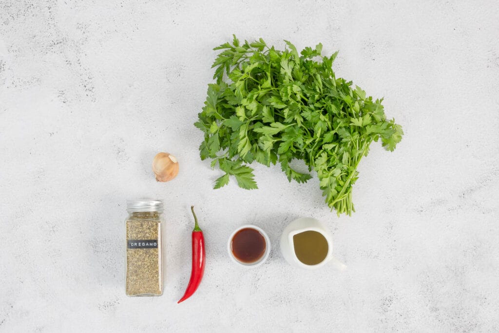 Petersilie, Oregano, Essig, él, Knoblauch und Chili auf dem Tisch