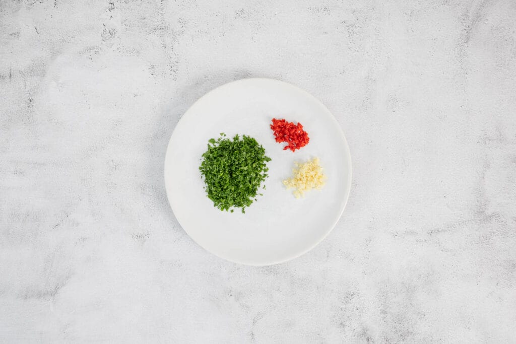 Petersilie, Knoblauch, Chili geschnitten auf dem Teller