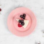 Veganer No-Bake Cheesecake mit Zuger Kirschen auf dem rosa Teller