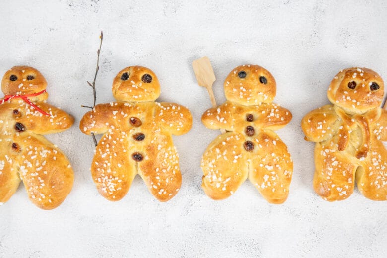 Vegane Grittibänze mit Hagelzucker, Rosinen und Dekoration auf dem Tisch