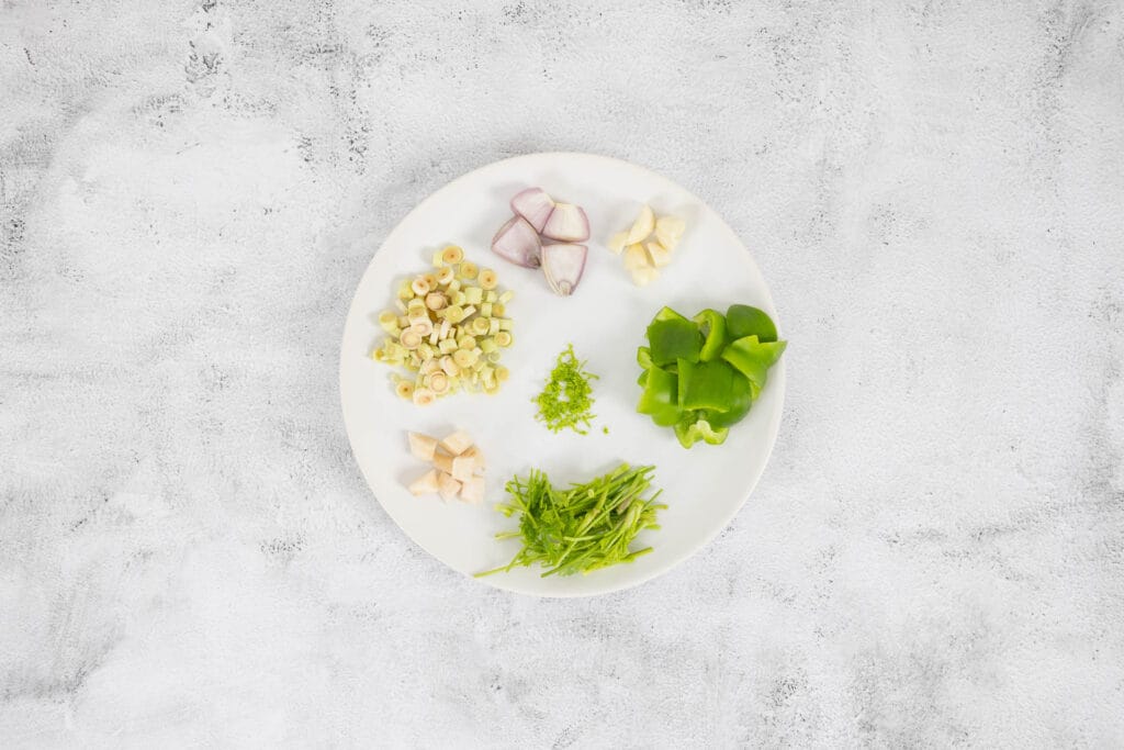Geschnittene Zutaten für vegane grüne Thai-Currypaste auf einem Teller, Foodblog Rezeptaufnahme von oben