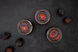 Rotweinzwetschgen in Gläsern mit frischen Zwetschgen – traditionelles Rezept aus der Schweiz zum Einmachen