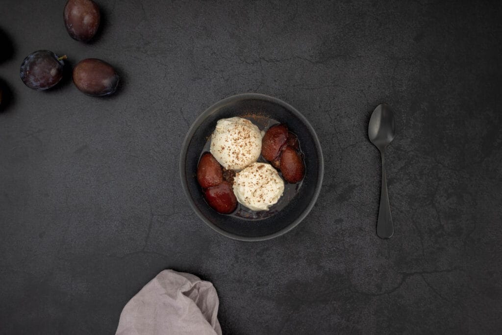 Rotweinzwetschgen mit Vanilleglace serviert – süsses Dessert aus eingemachten Zwetschgen, accidentally vegan