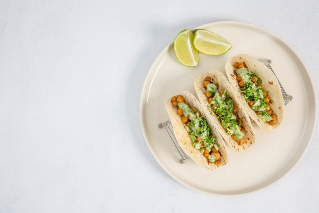 Teller mit Kichererbsen-Tacos und frischen Limetten – Airfryer-Rezept mit Koriander und würziger Paprikanote