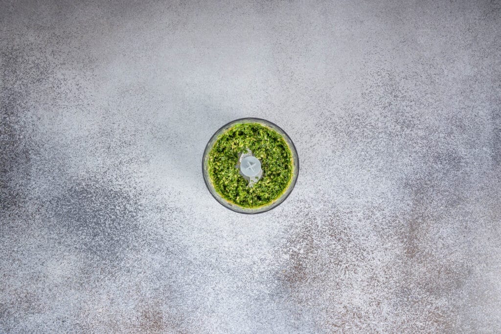 Erster Mixdurchgang im Food Processor: grob gemixtes Basilikum-Pesto, leuchtend grün und frisch aus der italienischen Küche inspiriert