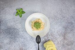 Spaghetti mit veganem Pesto Genovese angerichtet, frischer Basilikum daneben – einfaches italienisches Pastagericht ohne Parmesan