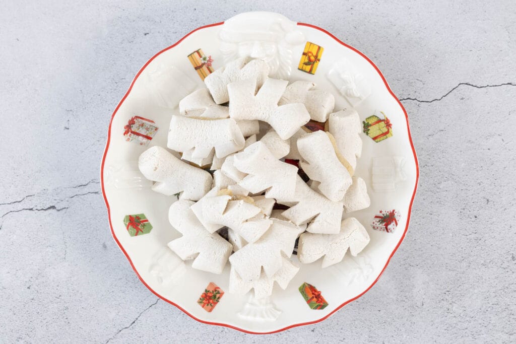 Detailaufnahme traditioneller veganer Chräbeli auf einem Weihnachtsteller – Anisguetzli aus der Schweiz