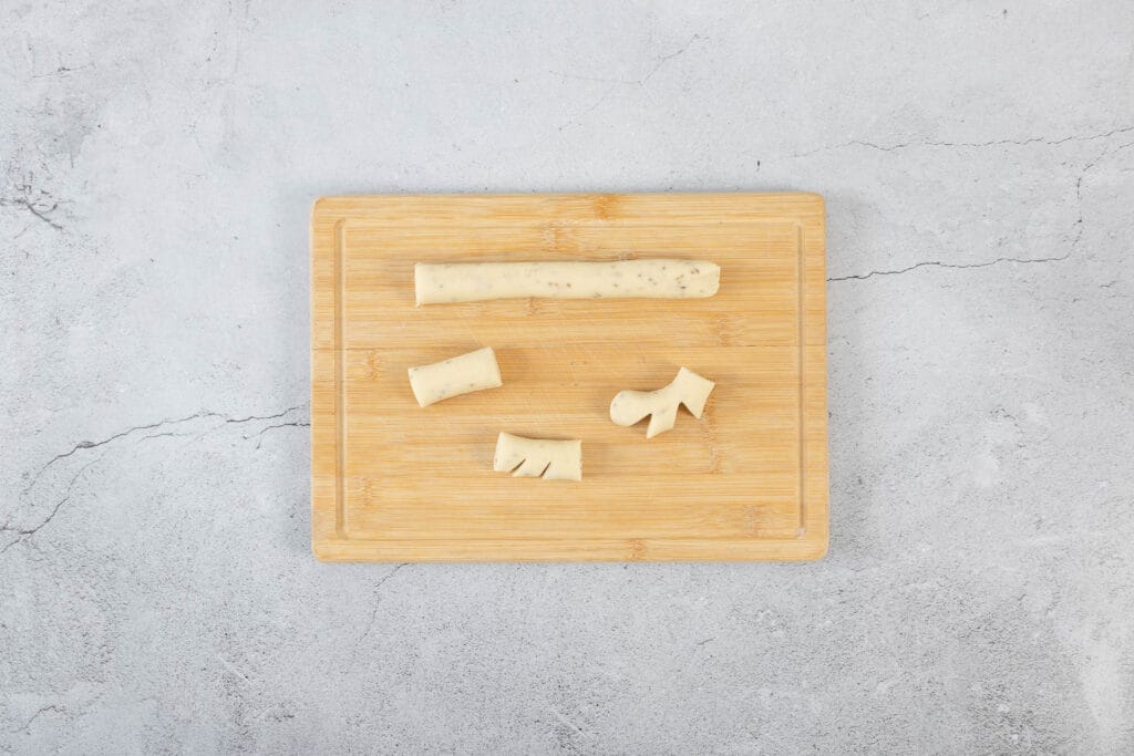 Schritt-für-Schritt-Formen von veganen Chräbeli: Teigrolle, geschnittene Stücke und eingeschnittene Anischräbeli