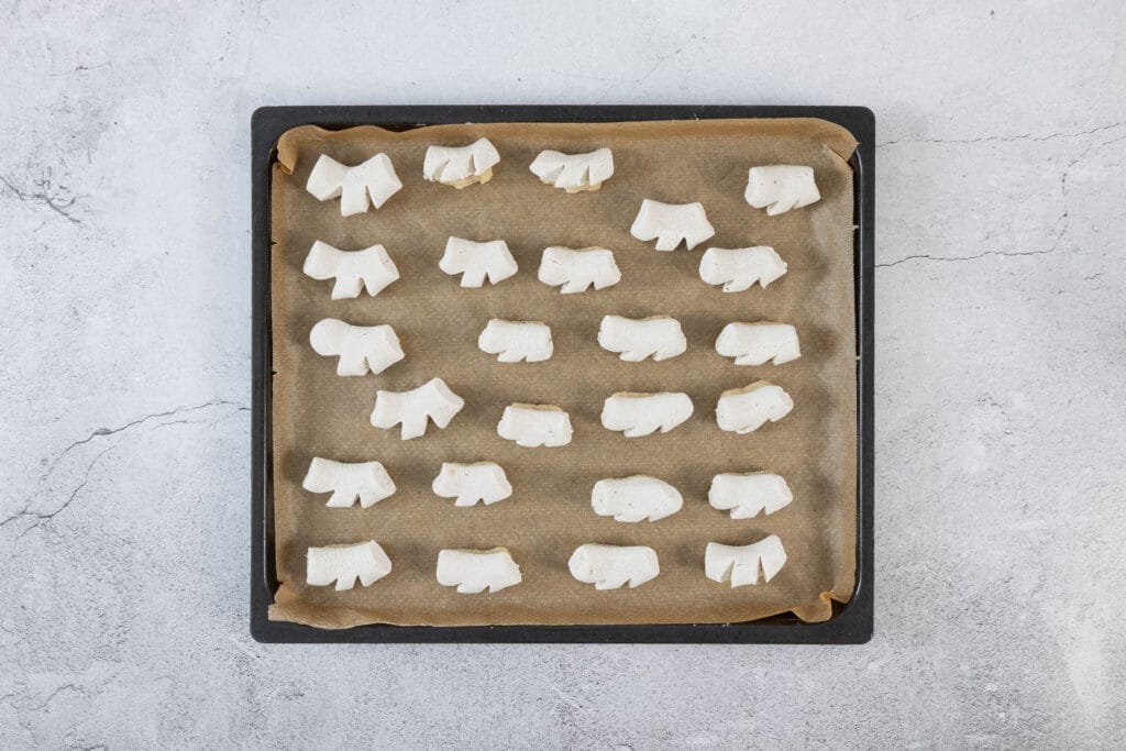 Frisch gebackene vegane Chräbeli mit heller Kruste auf dem Blech – traditionelle Anischräbeli vegan