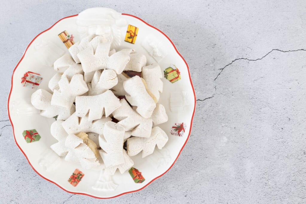 Nahaufnahme veganer Anischräbeli auf Weihnachtsteller – helle, aromatische Schweizer Chräbeli