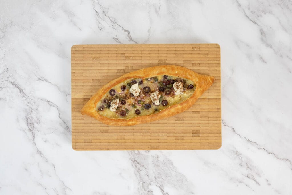 Frisch gebackenes Pide mit Oliven, Kapern und Zwiebeln – goldbraun und aromatisch aus dem Ofen