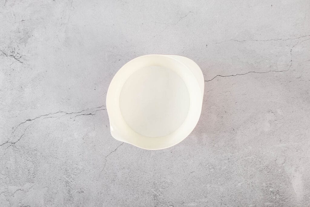 Aufgeschlagenes Aquafaba in einer weissen Rührschüssel als luftige Basis für vegane Kokosmakronen