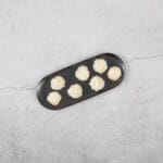 Vegane Kokosmakronen angerichtet auf schwarzer Platte als zarte, glutenfreie Weihnachtsguetzli