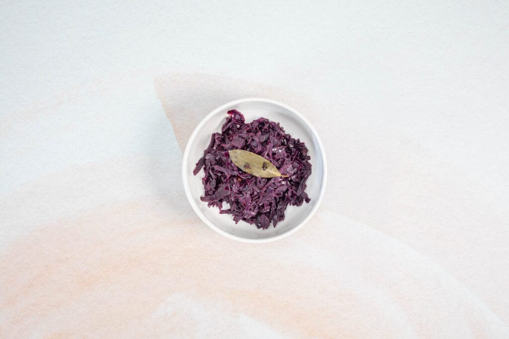 Rotkraut in einer weissen Schale mit Lorbeerblatt, serviert als klassischer Rotkohl oder Blaukraut