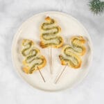 Festlich angerichtete vegane Blätterteig-Tannenbäume als weihnachtliches Apéro auf hellem Untergrund
