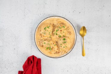 Marry Me Tofu servierbereit in Schüssel mit goldigem Löffel und roter Serviette daneben
