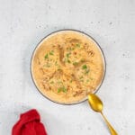 Schüssel mit Marry Me Tofu mittig, goldiger Löffel rechts und rote Serviette links