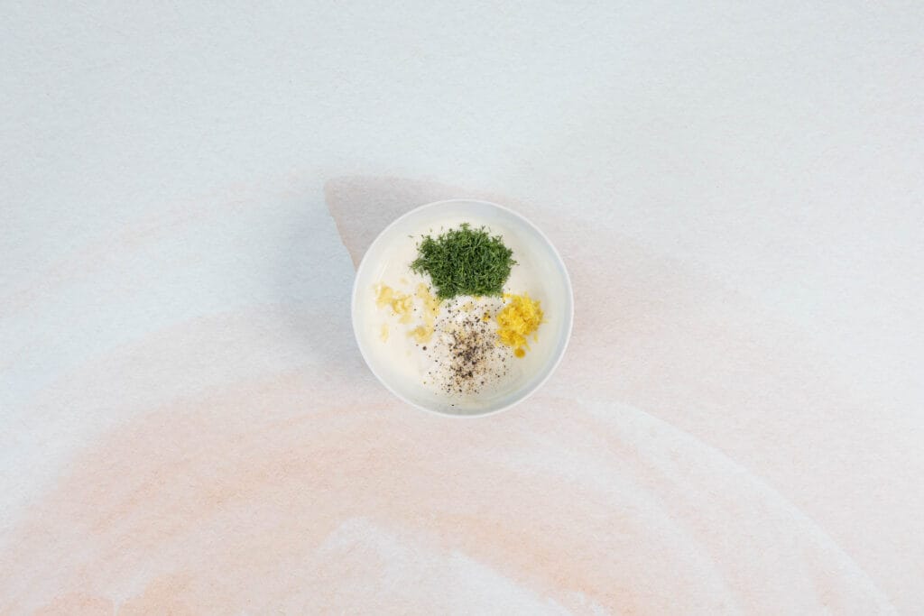Veganer Joghurt mit Dill, Zitronenabrieb, Knoblauch und Pfeffer als frischer Dip zu Zucchetti-Puffern