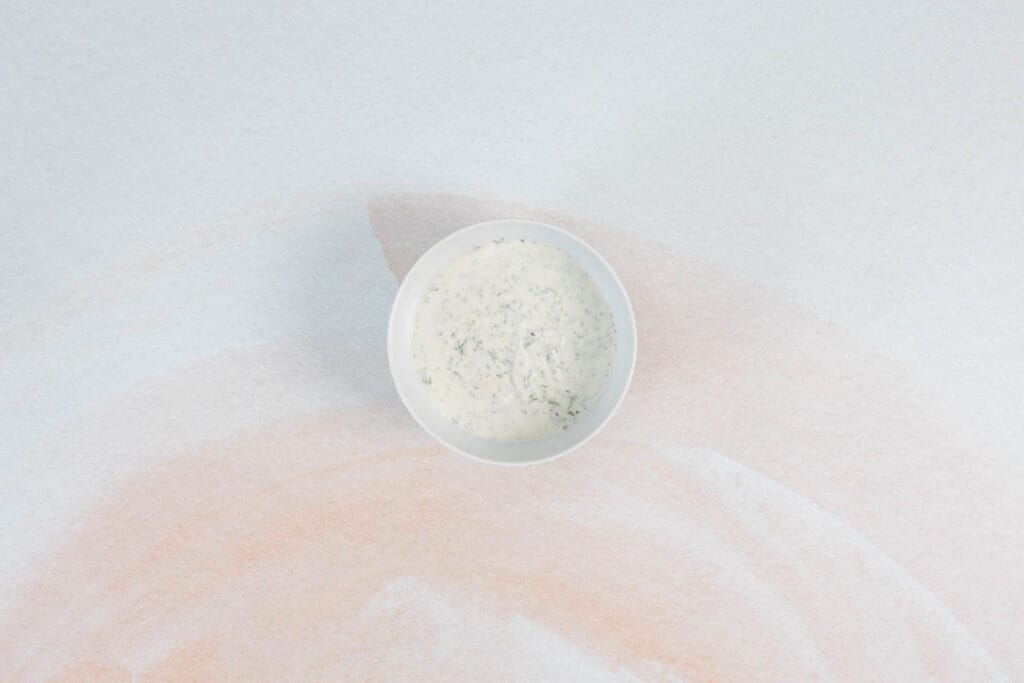 Veganer Joghurt-Dip mit Dill und Knoblauch angerührt, passend zu knusprigen Zucchetti-Puffern