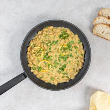 Mediterrane Riesenbohnen in cremiger Zitronensauce mit Petersilie in der Pfanne