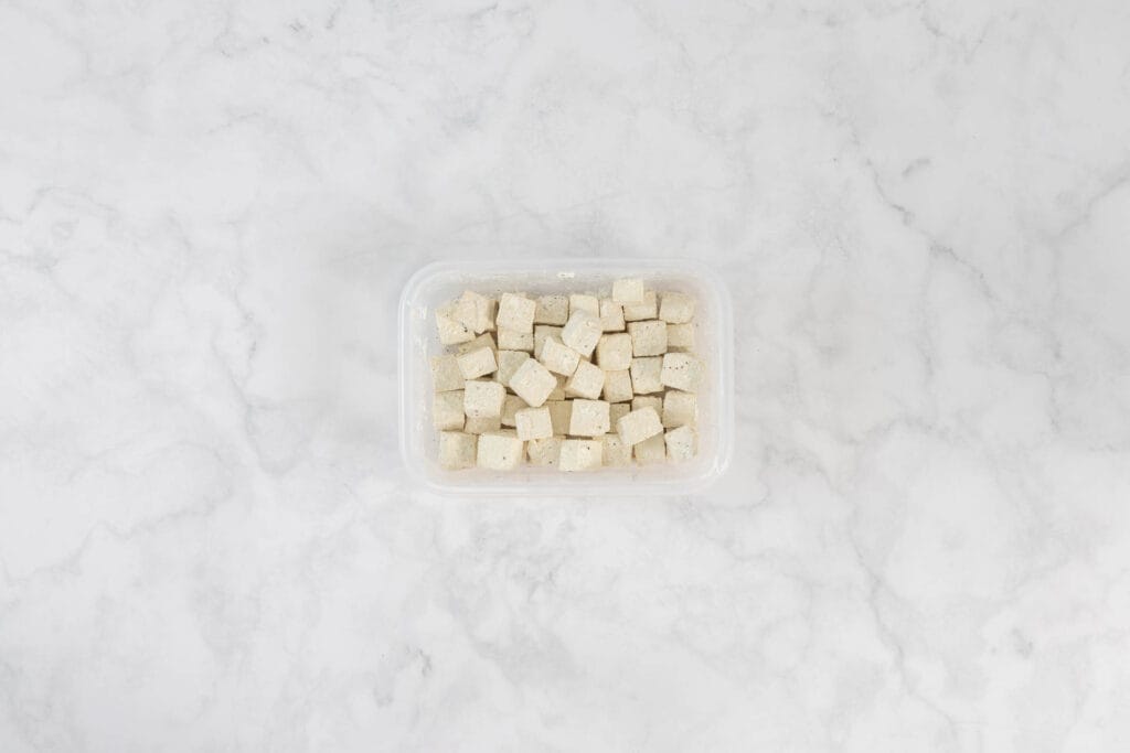 Gewürzte Tofuwürfel in verschliessbarer Dose geschüttelt