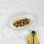 Gerösteter Rosenkohl aus dem Ofen angerichtet auf einer hellen Platte