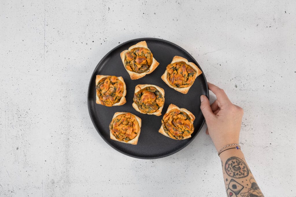 vegane Mini-Quiche Muffins auf schwarzem Teller als Apéro Fingerfood von oben fotografiert