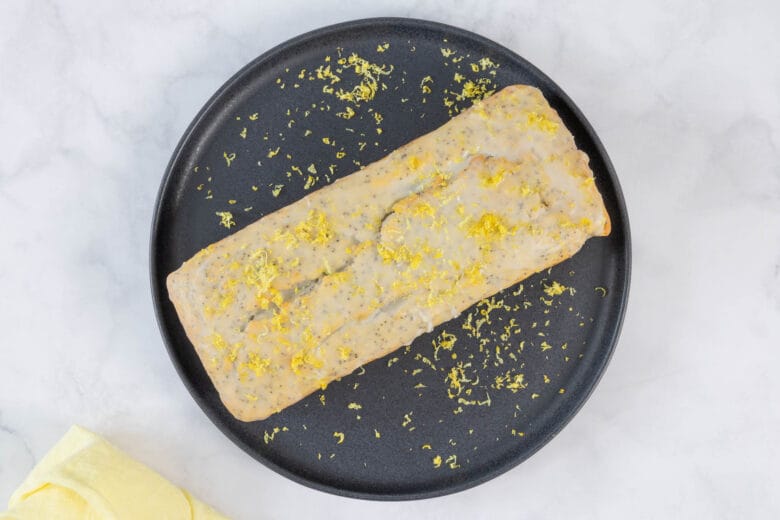 Detailaufnahme von veganem Zitronenkuchen mit Mohn und Glasur