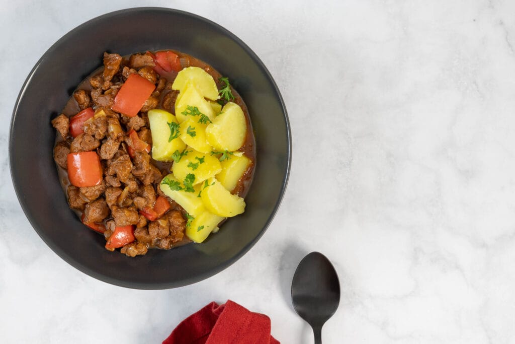 Veganes Gulasch Rezept angerichtet als herzhaftes Schmorgericht