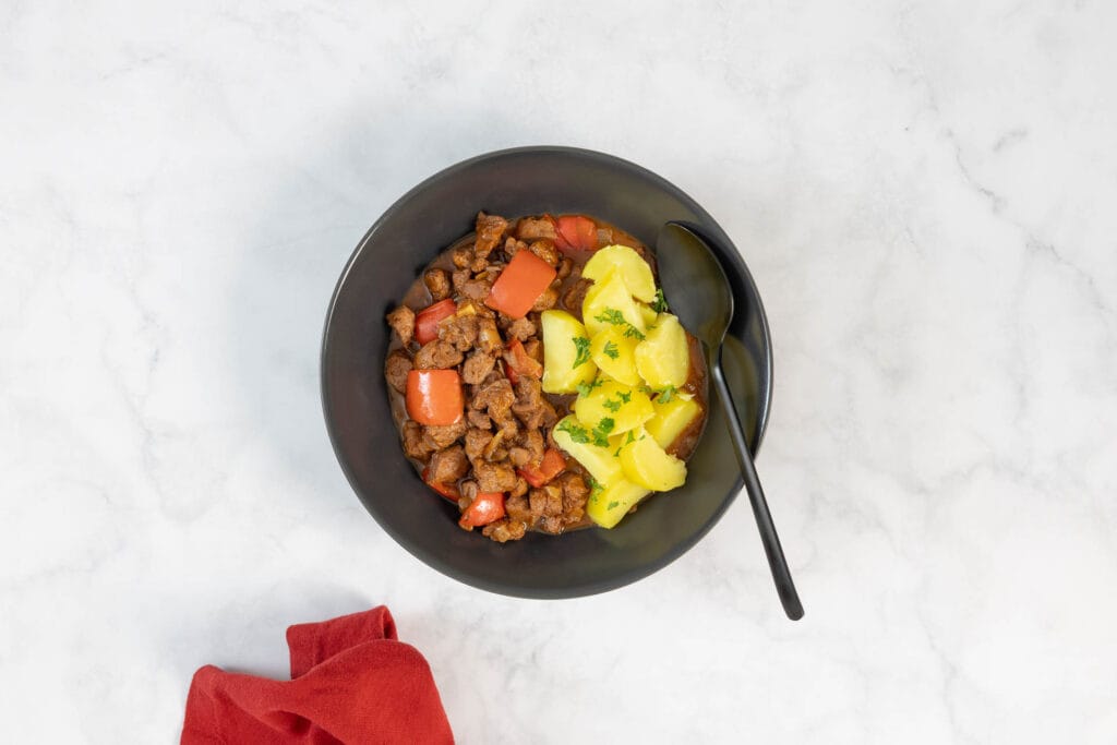 Veganes Gulasch mit Sojaschnetzeln und Paprika servierbereit in einer Schüssel