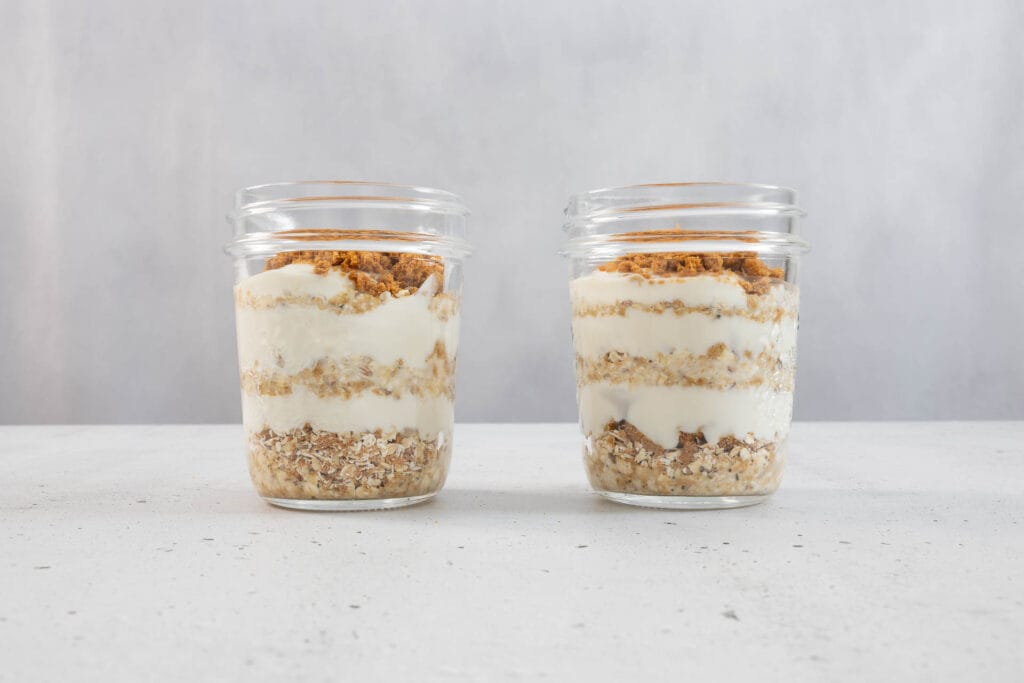 Vegane Overnight Oats Japanese Cheesecake mit klar erkennbaren Schichten aus Hafer, Joghurt und Lotus Biscoff